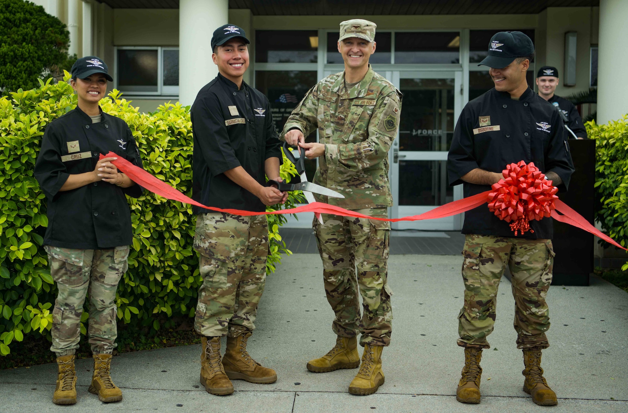 U.S. Air Force Col. Joshua Lundeby, 18th Wing deputy commander, and Airmen assigned to the 718th Force Support Squadron, perform a ribbon-cutting ceremony outside of the Marshall DFAC.