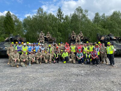 The combined 405th Army Field Support Brigade team made up of Soldiers and Army civilians from Army Field Support Battalion-Africa from Livorno, Italy, and contractors from the Coleman Army Prepositioned Stocks-2 worksite in Mannheim, Germany, as well as West Virginia Army National Guard Soldiers from the 1st Squadron, 150th Cavalry Regiment, pose for a photo before conducting a safety briefing May 2 at an APS-2 Equipment Configuration and Hand-off Area at the Libava Training Area in Libava, Czechia, at the start of DEFENDER 24.