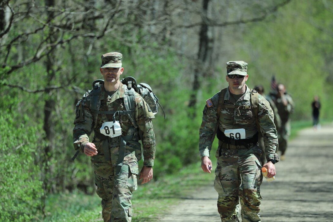 Two Wisconsin Army National Guard Soldiers march along the Glacial Drumlin State Trail as they participate in the Norwegian foot march on April 19, 2024. The Norwegian foot march challenges participants to complete 30 kilometers (18.6 miles) while carrying at least 24 pounds in a rucksack on their back. (U.S. National Guard photo by Staff Sgt. Amber Peck)