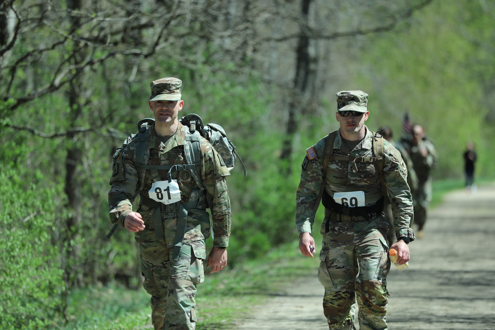Two Wisconsin Army National Guard Soldiers march along the Glacial Drumlin State Trail as they participate in the Norwegian foot march on April 19, 2024. The Norwegian foot march challenges participants to complete 30 kilometers (18.6 miles) while carrying at least 24 pounds in a rucksack on their back. (U.S. National Guard photo by Staff Sgt. Amber Peck)
