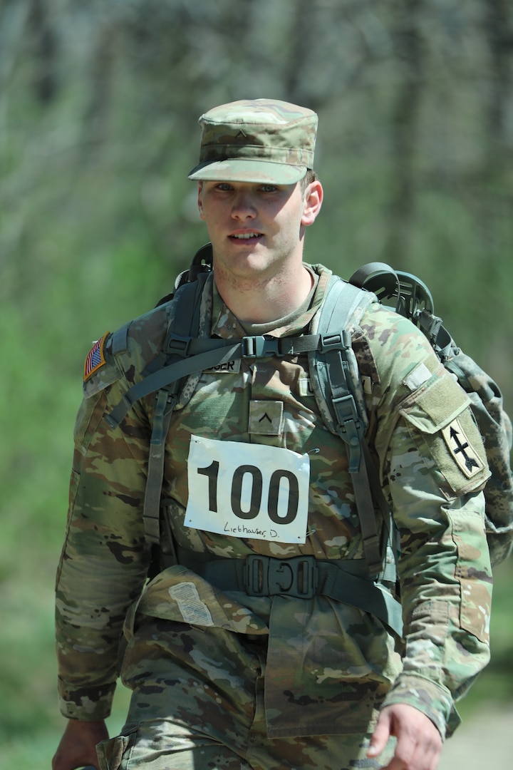 Pvt. 1st Class Dalton Liebhauser of Bravo Battery, 1st Battalion, 120th Field Artillery, marches along the Glacial Drumlin State Trail as he participates in the Norwegian foot march on April 19, 2024. The Norwegian foot march challenges participants to complete 30 kilometers (18.6 miles) while carrying at least 24 pounds in a rucksack on their back. (U.S. National Guard photo by Staff Sgt. Amber Peck)