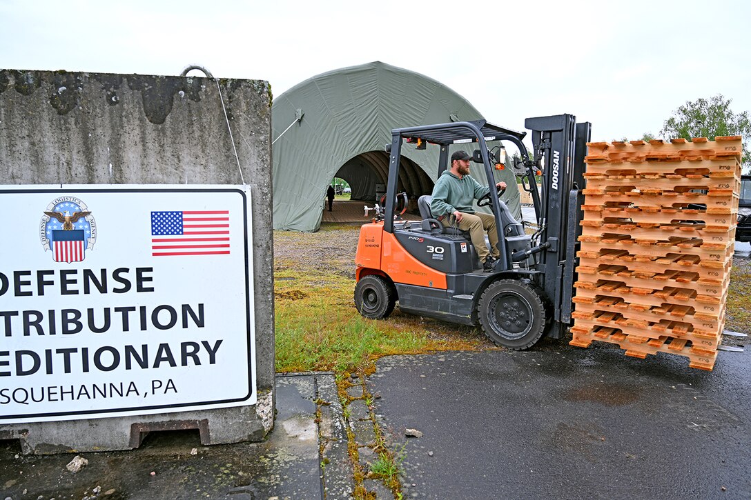 Man drives what looks like a forklift outdoors