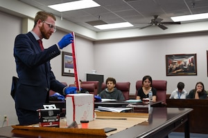 Special Agent Isaiah Moore, assigned to Air Force Office of Special Investigations Detachment 422, packages evidence at Altus Air Force Base, Oklahoma, May 1, 2024. Moore demonstrated the collection of evidence at a crime scene for the students of Mangum High School. (U.S. Air Force photo by Airman Lauren Torres)