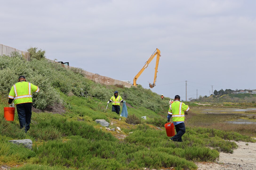 Workers with the City of Newport Beach and the Los Angeles District remove debris from several unauthorized encampments in the inner banks of the lower Santa Ana River Marsh April 19 in Newport Beach, California.