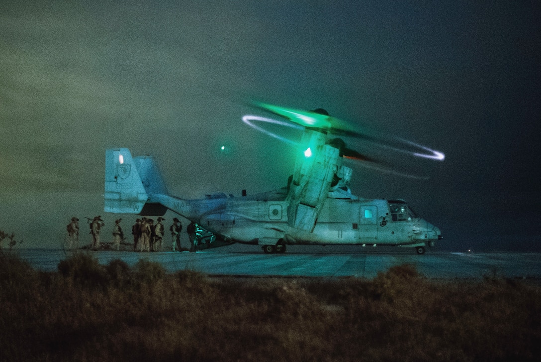 U.S. Marines and Sailors assigned to Reconnaissance Company, 15th Marine Expeditionary Unit, board an MV-22B Osprey attached to Marine Medium Tiltrotor Squadron (VMM) 165 (Reinforced), 15th MEU, at a simulated landing helicopter dock pad during a raid exercise on Marine Corps Base Camp Pendleton, California, April 24, 2024. The LHD pad is a landing zone that matches the flight deck dimensions of a U.S. Navy amphibious assault ship, allowing pilots to simulate landing on a ship. (U.S. Marine Corps photo by Cpl. Joseph Helms)