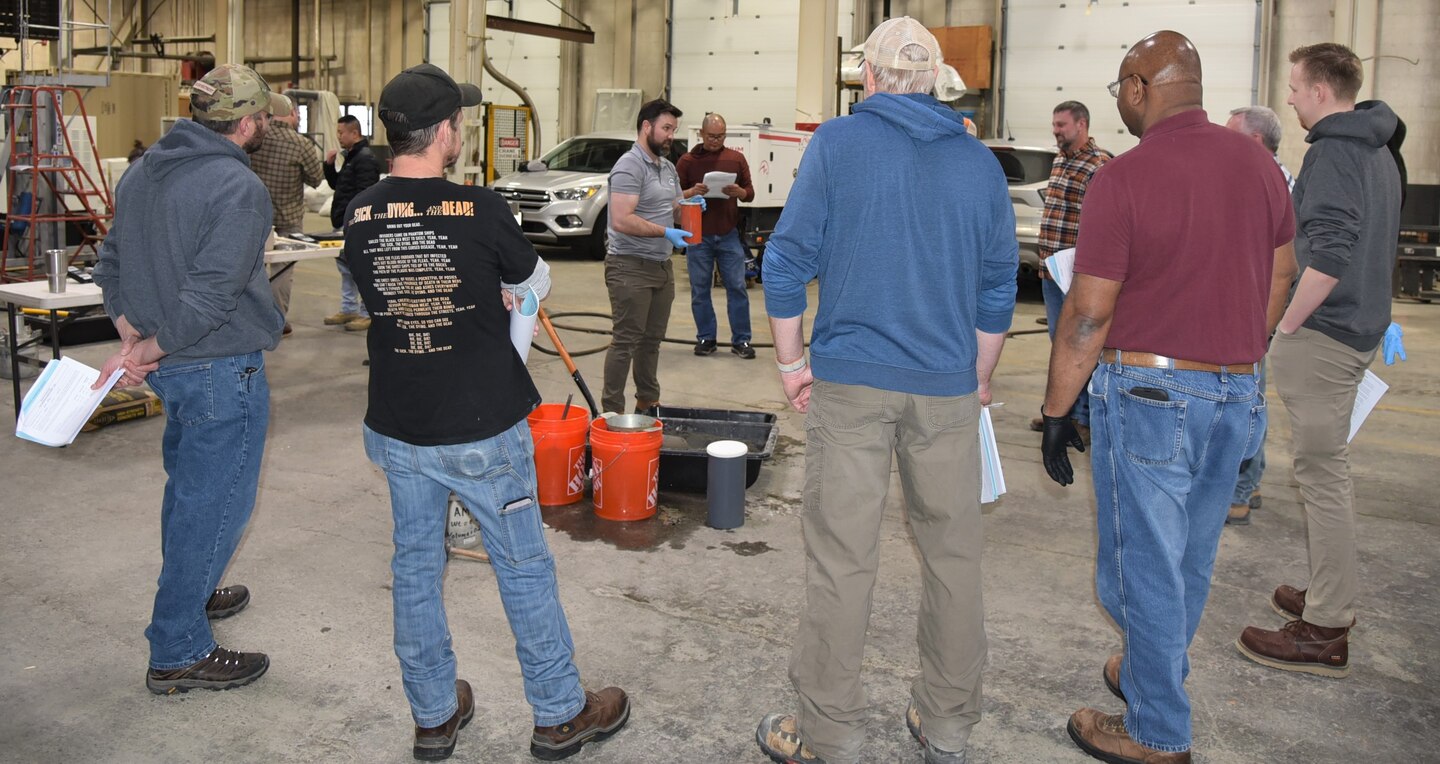Workshop participants look on as Justin Miller (center), geotechnical engineer and materials subject matter expert, discusses the practical element of the American Concrete Institute's Level One Concrete Certification Exam.