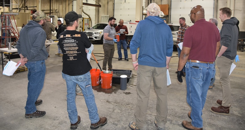 Workshop participants look on as Justin Miller (center), geotechnical engineer and materials subject matter expert, discusses the practical element of the American Concrete Institute's Level One Concrete Certification Exam.