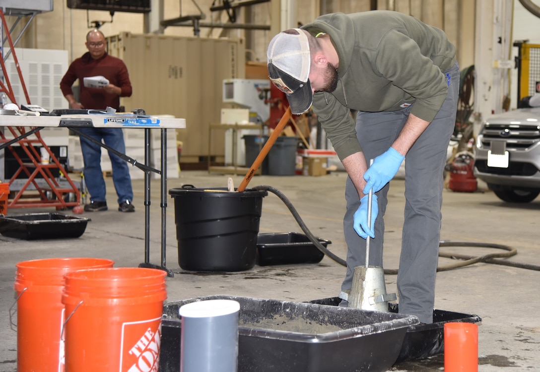 Adam Hartzheim, geotechnical engineer, performs a slump test during the ACI practical exam.