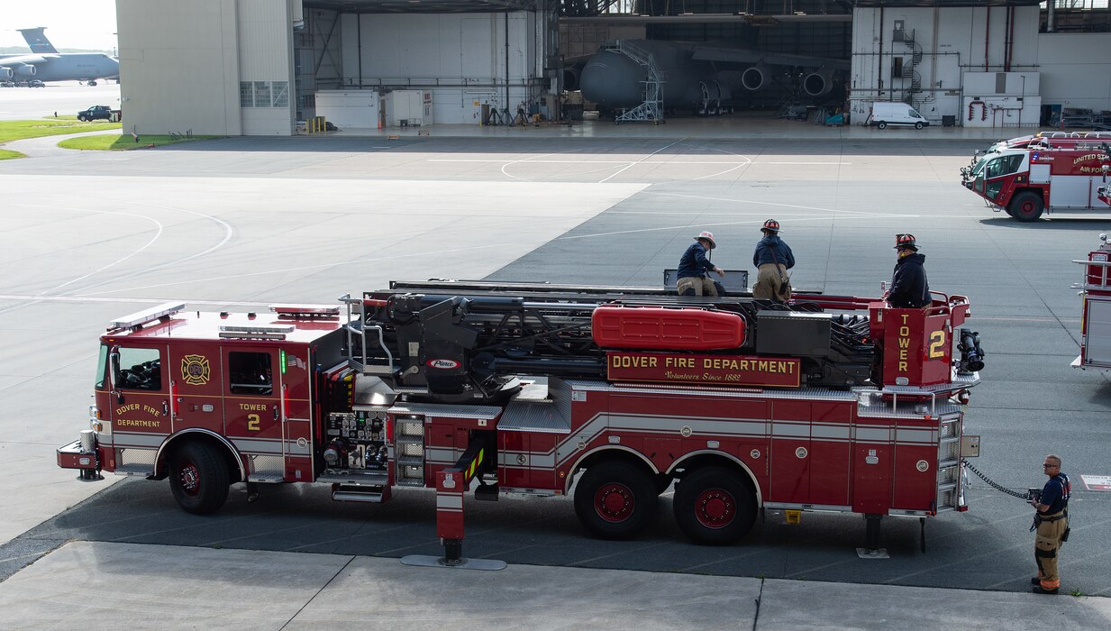 Members of the Dover Fire Department, set up their ‘Tower 2’ ladder truck at Dover Air Force Base, Delaware, May 3, 2024. Dover AFB first responders and the Dover Fire Department participated in an annual confined-space extraction exercise of a mannequin overcome by simulated fuel vapors on top of the left wing of a C-5M Super Galaxy. (U.S. Air Force photo by Roland Balik)