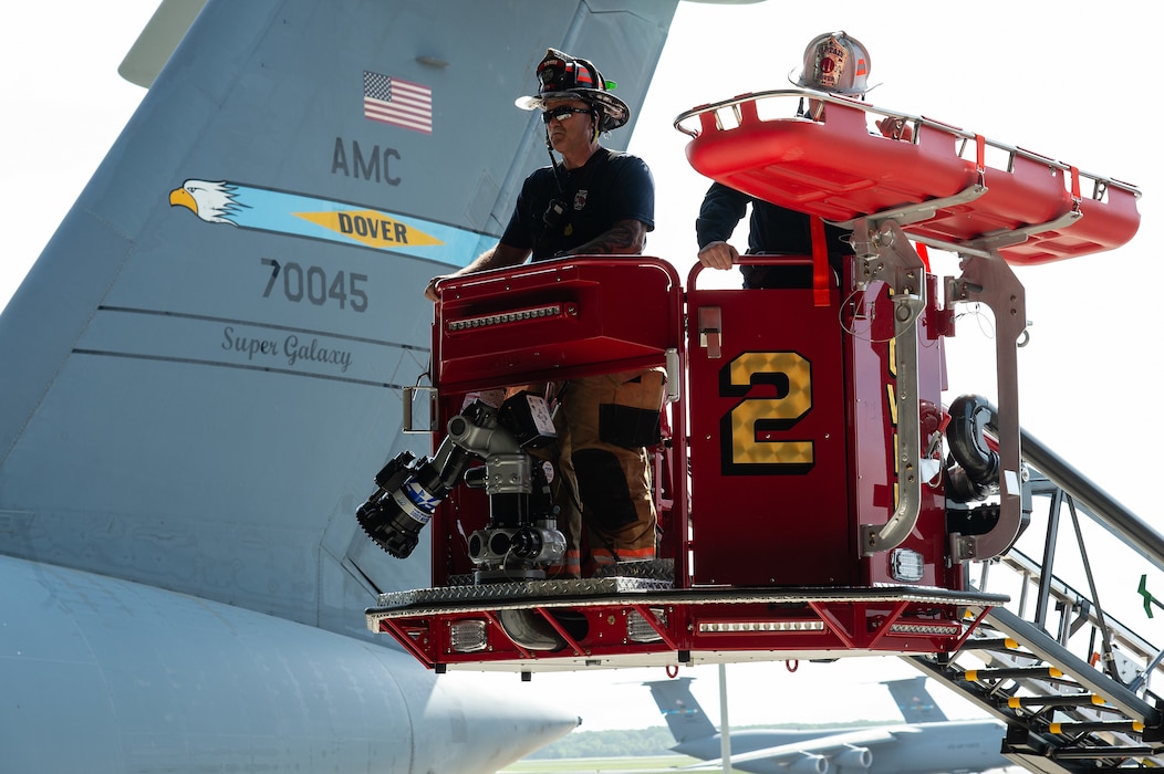 Brian Cullen, Dover Fire Department firefighter, steers the basket of their ‘Tower 2’ ladder truck into position at Dover Air Force Base, Delaware, May 3, 2024. Dover AFB first responders and the Dover Fire Department participated in an annual confined-space extraction exercise of a mannequin overcome by simulated fuel vapors on top of the left wing of a C-5M Super Galaxy. (U.S. Air Force photo by Roland Balik)