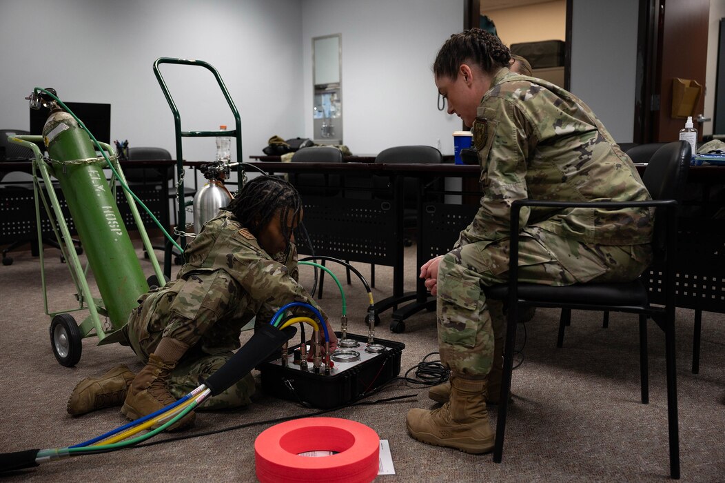 U.S. Air Force Tech. Sgt. Krystal Champ, 354th Medical Group independent duty medical technician (left), and Lt. Col. Ashley Franz, 87th Medical Group chief of aerospace medicine (right), run through set up procedures on a portable decompression sickness chamber, Hyperlite 1, during a three-day hyperlite chamber training course at Eielson Air Force Base, Alaska, May 3, 2024.