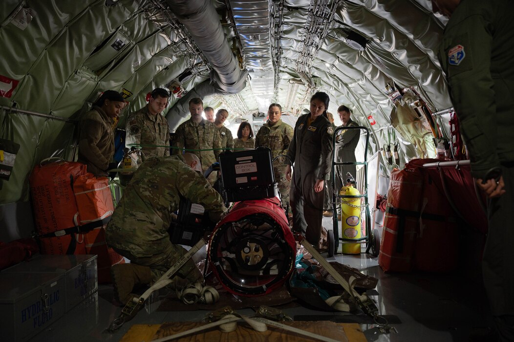 Airmen from the 354th Medical Group watch a demonstration of a portable decompression sickness chamber, Hyperlite 1, on a KC-135 Stratotanker at Eielson Air Force Base, Alaska, May 3, 2024.