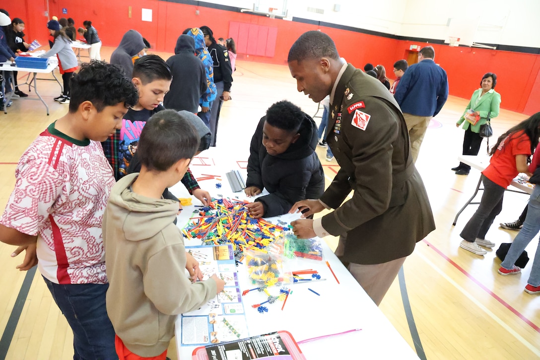 Lt. Col. Stephen Brooks, U.S. Army Corps of Engineers Los Angeles District deputy command-er, right, works with students on a STEM-related activity during the West Point Leadership in Ethics and Diversity in STEM Workshop April 5 in Carson, California.