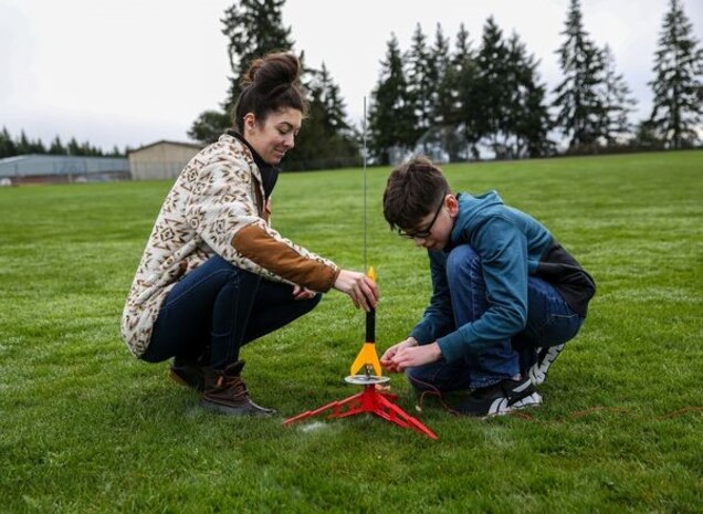 Strategic Weapons Facility-Pacific Science, Technology, Engineering, and Math (STEM) Lead Chani Wenning steadies a rocket while a student from Ridgetop Middle School’s Introduction to Engineering class connects the launcher to the fuse inside the rocket engine. SWFPAC STEM volunteers have partnered with Ridgetop and the Intro to Engineering class to host rocket launches for the last two school years, giving students an opportunity to plan, build, and launch their own rockets.