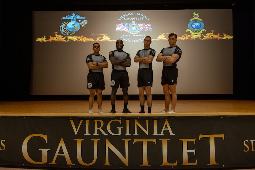 Four Marines pose on a stage.