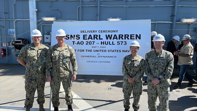 From left to right, Cmdr. Mark Ewachiw, Supervisor of Shipbuilding, Bath - San Diego Detachment, Officer in Charge;  Lt. Elliot Collins, Project Officer; Lt. Allison Adamos, Project Officer; and Lt. Cmdr. René Martin, T-AO Program Manager Representative attend the USNS Earl Warren (T-AO 207) Delivery Ceremony, in San Diego, Calif., May 7, 2024.