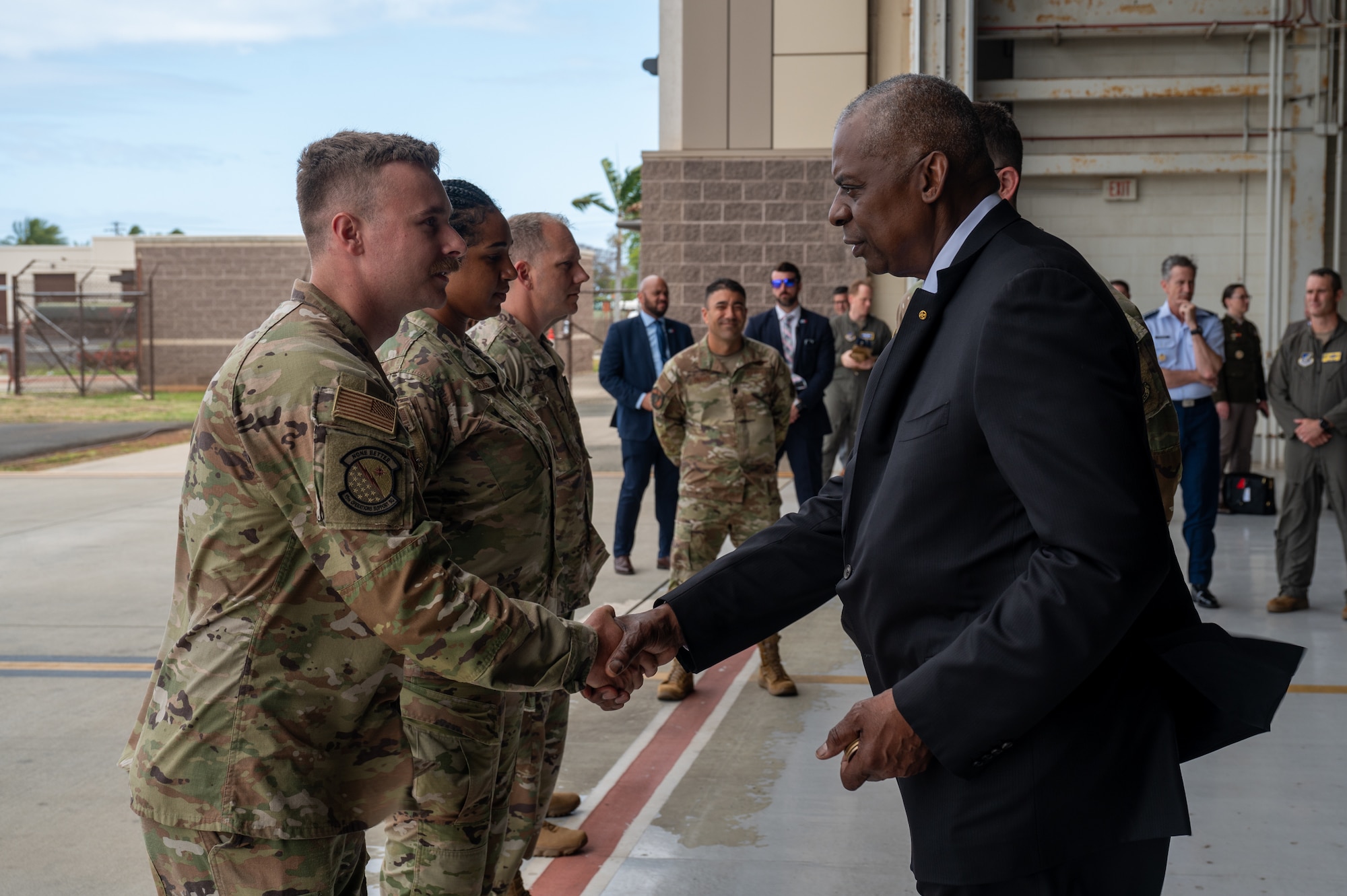 Secretary of Defense shakes an Airman's hand while giving thema coin.