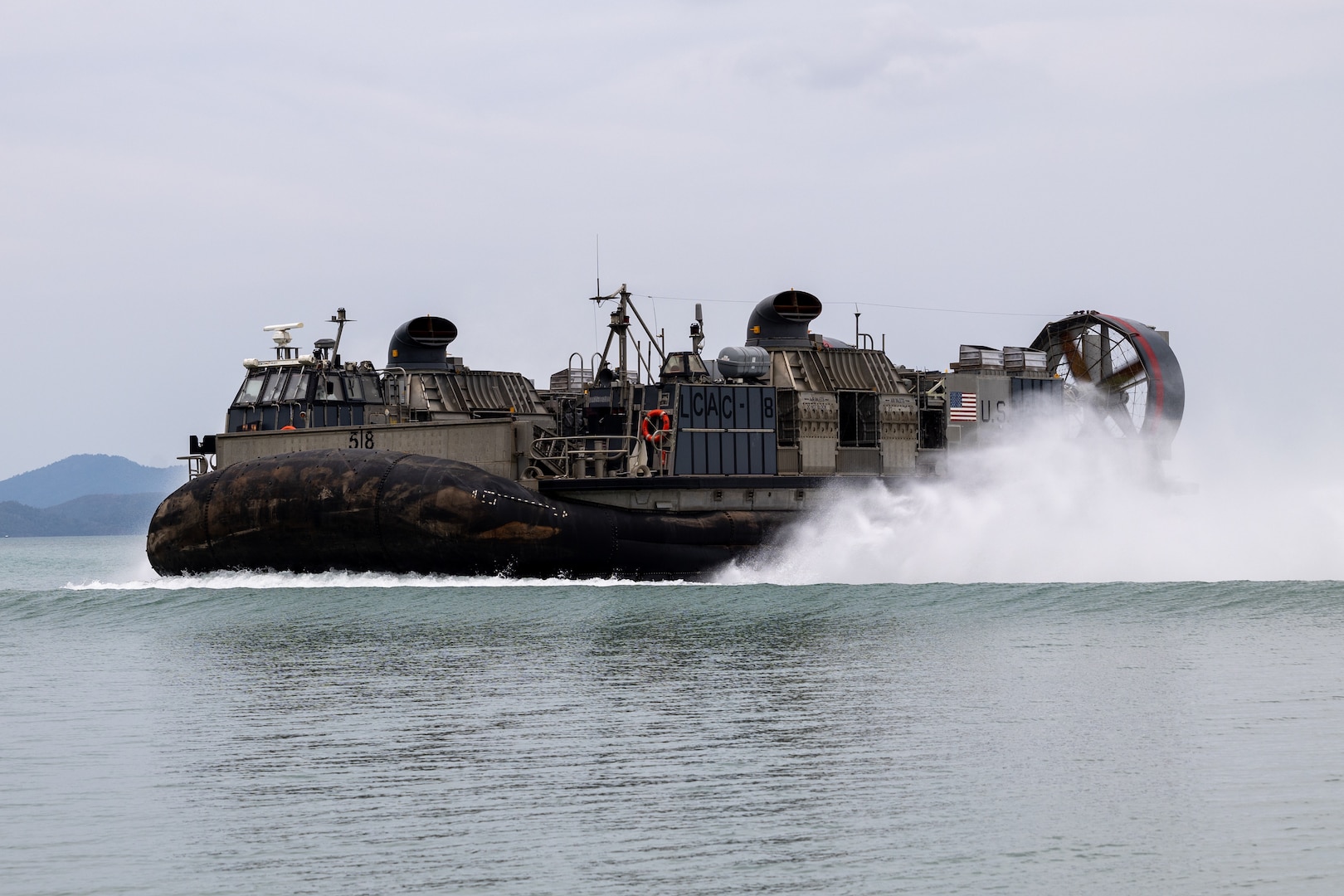 U.S. Navy Landing Craft, Air Cushion 45, attached to AssaultCraft Unit 5, prepares to land ashore with an M142 High Mobility Rocket System assigned to 3rd Platoon, Alpha Battery, 1st Long Range Fires Battalion, 1st Multi-Domain Task Force as part of a HIMARS Rapid Infiltration drill during Exercise Balikatan 24 at San Vicente, Philippines, May 1, 2024. BK 24 is an annual exercise between the Armed Forces of the Philippines and the U.S. military designed to strengthen bilateral interoperability, capabilities, trust, and cooperation built over decades of shared experiences. (U.S. Marine Corps photo by Cpl. Kyle Chan)