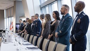 People in formal military dress standing before a table