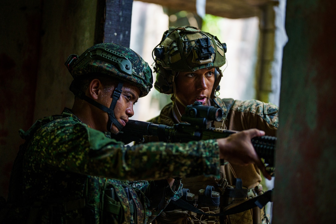 U.S. Marine Corps Sgt. Tyler Jordan, a native of Illinois and a machine gunner with 3rd Littoral Combat Team, 3rd Marine Littoral Regiment, 3rd Marine Division, moves through urban terrain alongside a  Philippine Marine with Marine Battalion Landing Team 10 while conducting urban operations training during Balikatan 24 at Paredes Air Station, Philippines, April 27, 2024. BK 24 is an annual exercise between the Armed Forces of the Philippines and the U.S. military designed to strengthen bilateral interoperability, capabilities, trust, and cooperation built over decades of shared experiences. (U.S. Marine Corps photo by Cpl. Malia Sparks)