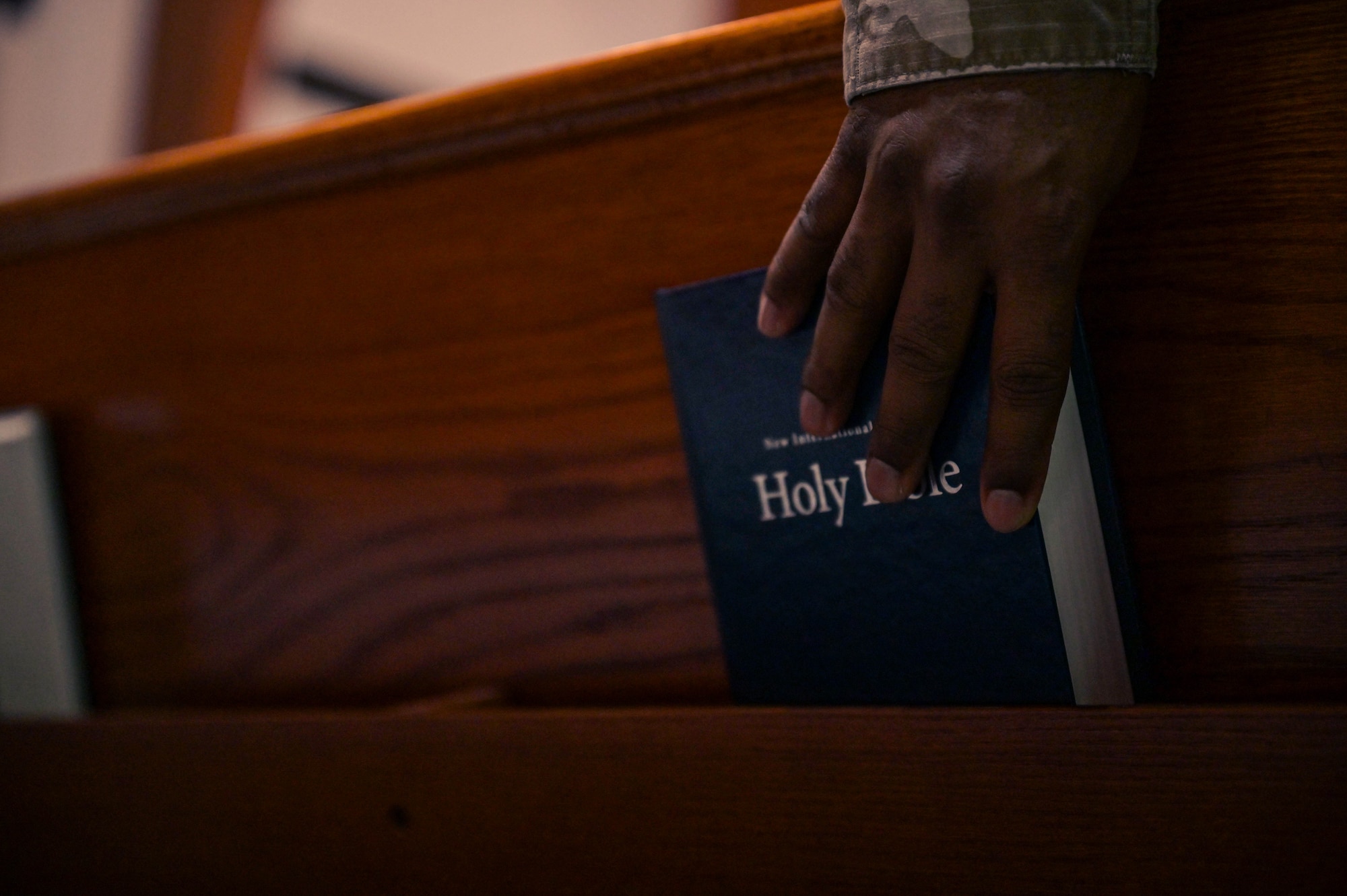 U.S. Air Force Senior Airman Roiel Swift, a 1st Special Operations Wing religious affairs Airman, places a bible into a pew at the Chapel at Hurlburt Field, Florida, April 16, 2024.
