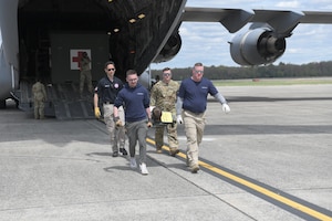 A four-person litter team carries a patient off of an Air Force transport aircraft during a mass casualty evacuation exercise at Westover Air Reserve Base on May 4.
