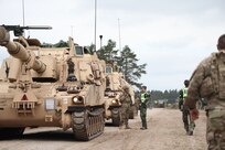 U.S. Army Spc. Crandale Jackson, a cannon crewmember assigned to Charlie Battery, 1st Battalion, 214th Field Artillery Regiment, 648th Maneuver Enhancement Brigade, Georgia Army National Guard, speaks to Swedish Military Police during DEFENDER 24 in Skillingaryd, Sweden, May 5, 2024. DEFENDER 24 is the Dynamic Employment of Forces to Europe for NATO Deterrence and Enhanced Readiness, and is a U.S. European Command scheduled, U.S. Army Europe and Africa conducted exercises that consist of Saber Strike, Immediate Response and Swift Response.