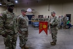 Master Sgt. Robert Yates, first sergeant of the 1245th Transportation Company, 345th Combat Sustainment Support Battalion, 90th Troop Command, Oklahoma Army National Guard during the company’s 2018-2019 deployment, attaches a Meritorious Unit Commendation ribbon to the company’s guidon during a ceremony at the Ada Readiness Center, Ada, Oklahoma, May 4, 2024. The unit was awarded the commendation in recognition of their accomplishments during their 2018-2019 deployment to Kuwait in support of Operation Spartan Shield and Operation Inherent Resolve. (Oklahoma National Guard photo by Cpl. Danielle Rayon)