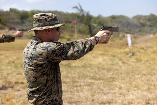 A U.S. Marine shoots a pistol.