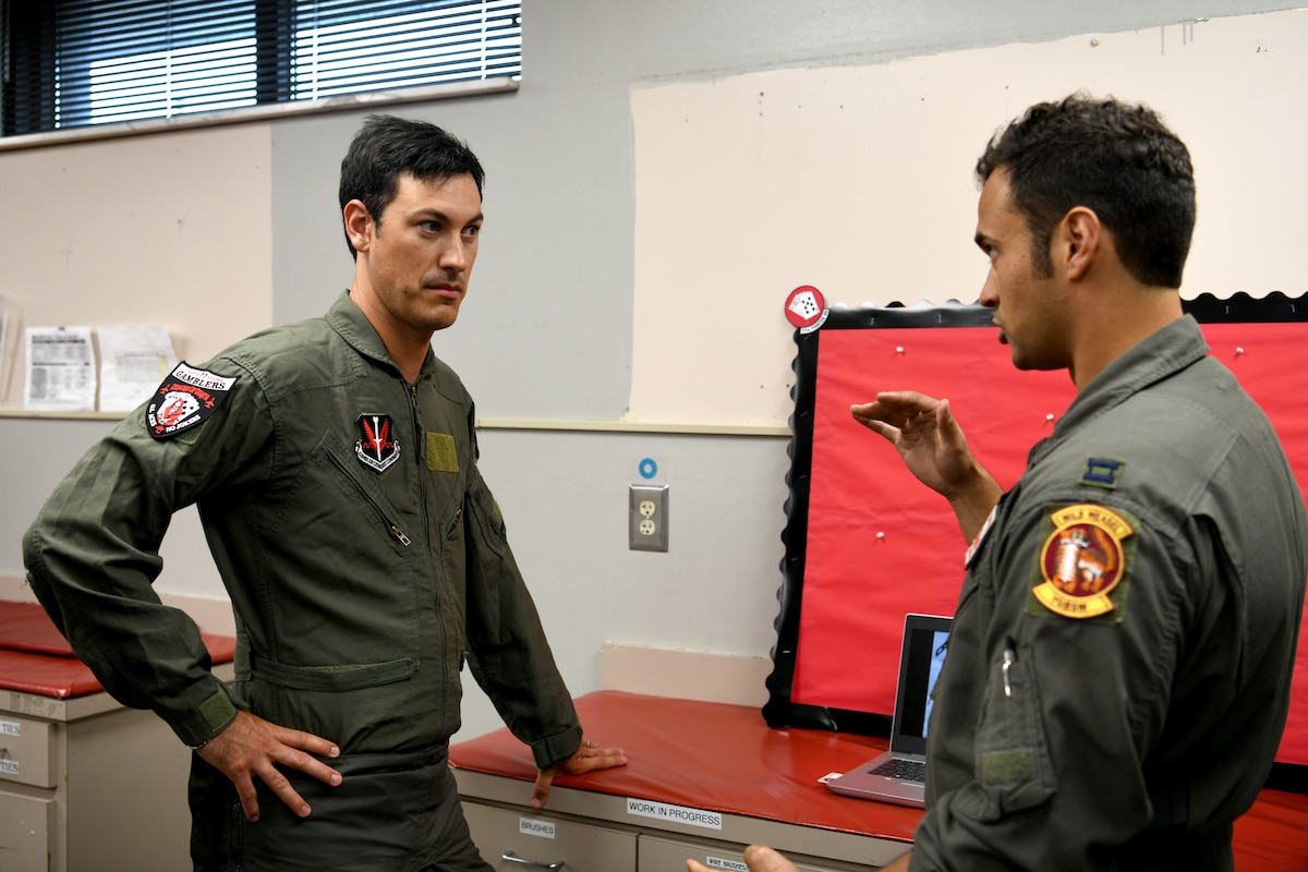 U.S. Air Force Capt. James Salem, 77th Fighter Squadron F-16 Fighting Falcon pilot, right, describes emergency ejection procedures to NASCAR driver Joey Logano prior to Logano’s flight in an F-16 at Shaw Air Force Base, S.C., May 7, 2024. Logano spent the day at Shaw AFB, receiving medical clearance, pre-flight training, equipment fitting and a mission briefing prior to his flight. (U.S. Air Force photo by Staff Sgt. Kelsey Owen)