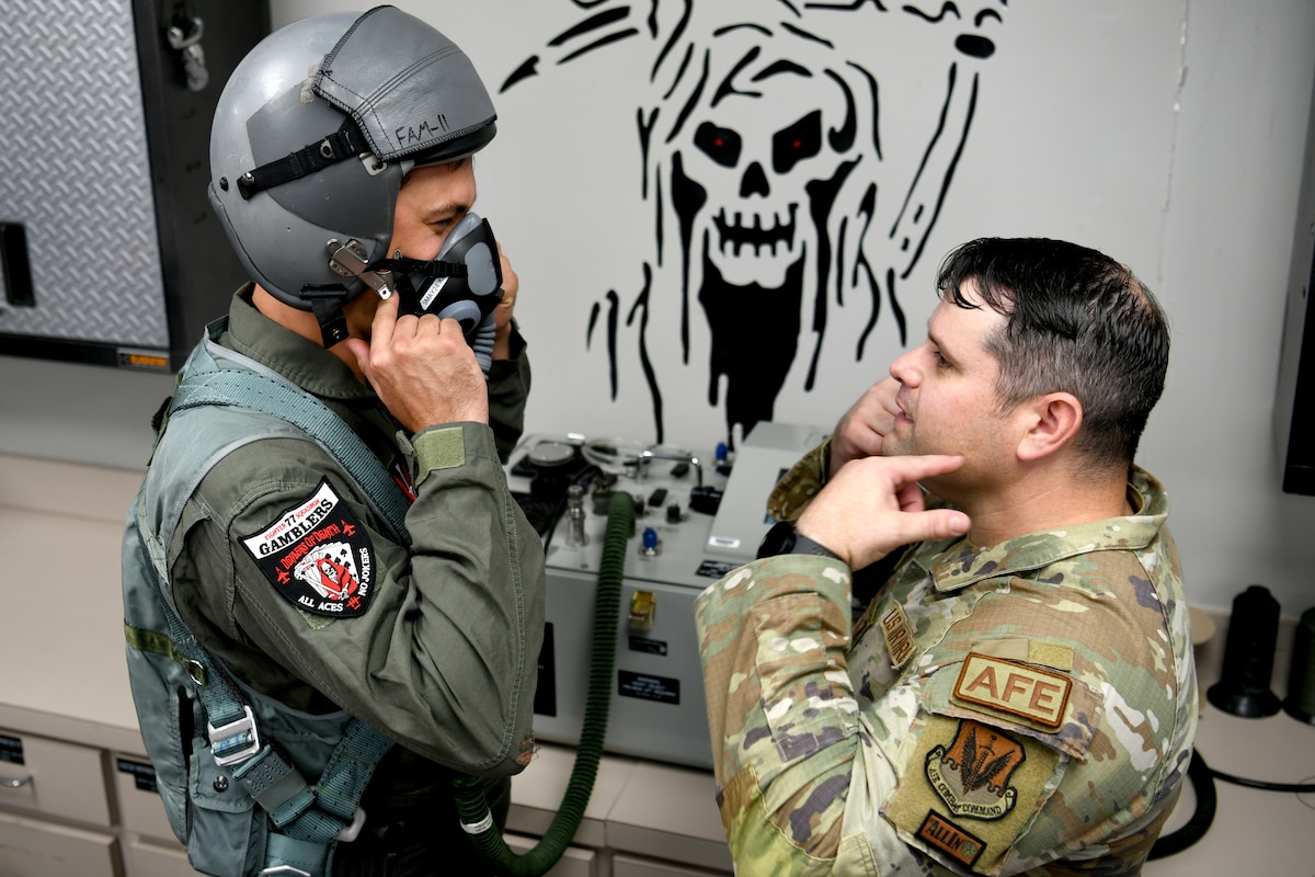 U.S. Air Force Tech. Sgt. Dustin Coffman, 20th Operations Support Squadron Aircrew Flight Equipment technician, right, shows NASCAR driver Joey Logano how to remove his oxygen mask at Shaw Air Force Base, S.C., May 7, 2024. Logano spent the day at Shaw AFB, receiving medical clearance, pre-flight training, equipment fitting and a mission briefing prior to his flight. (U.S. Air Force photo by Staff Sgt. Kelsey Owen)