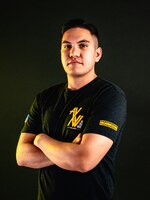 Man with a polo standing in front of a black background.