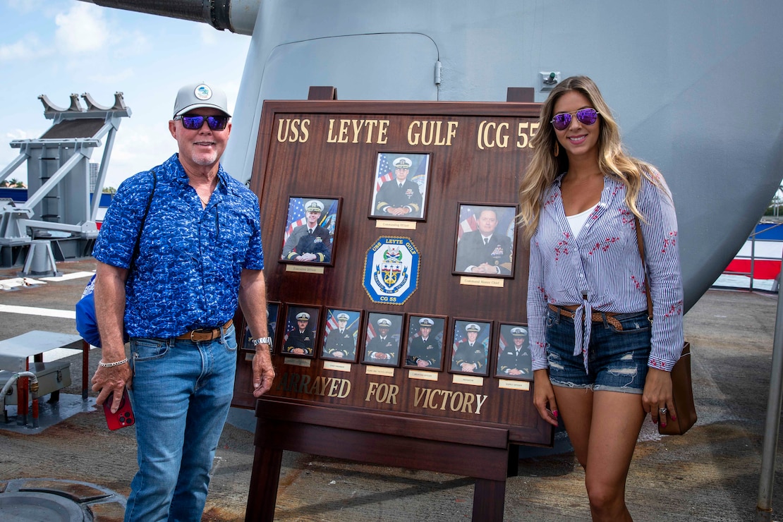 240507-N-LK647-1012 MIAMI (May 7, 2024) “Captain” Rick Murphy, host of Sportsman’s Adventures, and Brie Gabrielle, host of Florida Insider Fishing Report, pose for a photo on the quarterdeck of USS Leyte Gulf (CG 55) during Fleet Week Miami at PortMiami, May 7, 2024.