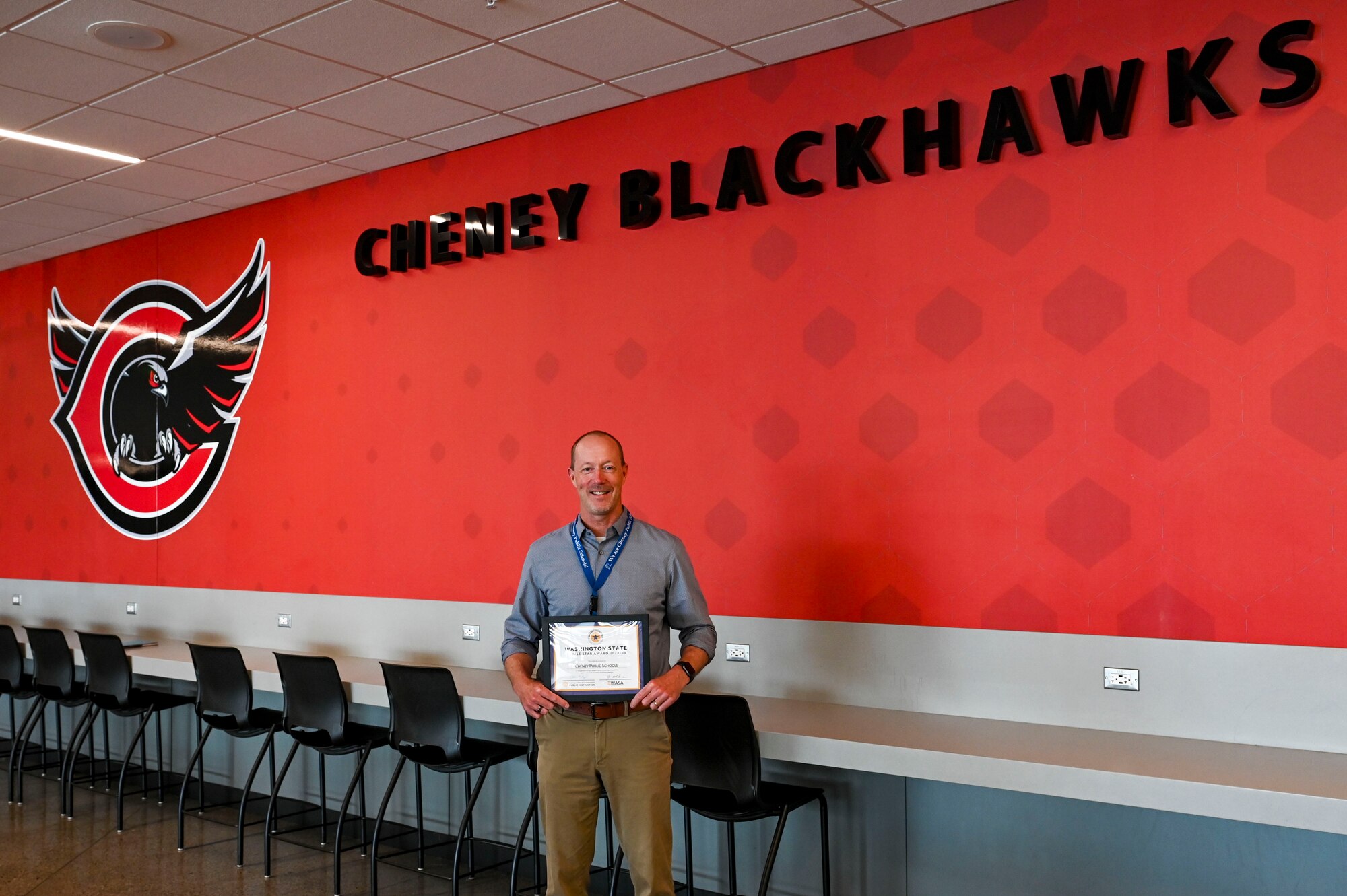 A man poses with an award certificate.