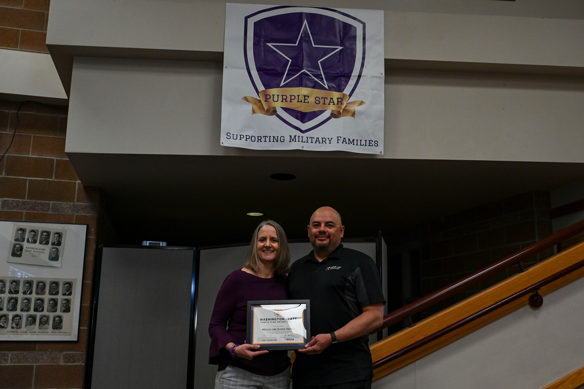 People pose with an award certificate.