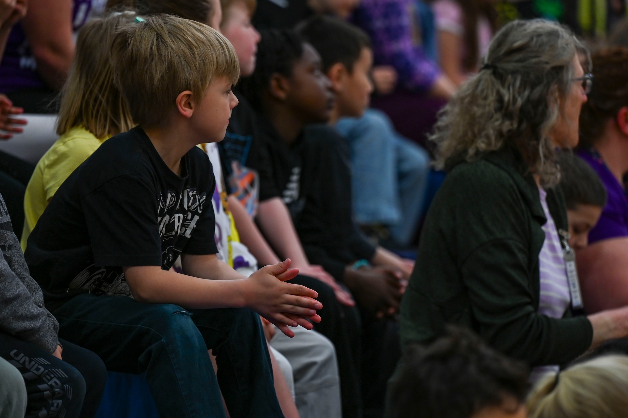 Children listen to a speaker in an audience.