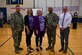 Michael Anderson Elementary School, Medical Lake School District and Fairchild Air Force Base leaders pose for a group photo after a Purple Up assembly at Fairchild Air Force Base, Washington, April 15, 2024. Medical Lake School District held the Purple Up assembly to celebrate The Month of the Military Child and Purple Star designation. Medical Lake School District received a Purple Star designation, April 5, 2024. The Washington State Legislature approved the Purple Star program last year, recognizing school districts that demonstrated a commitment to support the needs of students in military families. (U.S. Air Force photo by Airman 1st Class Clare Werner)