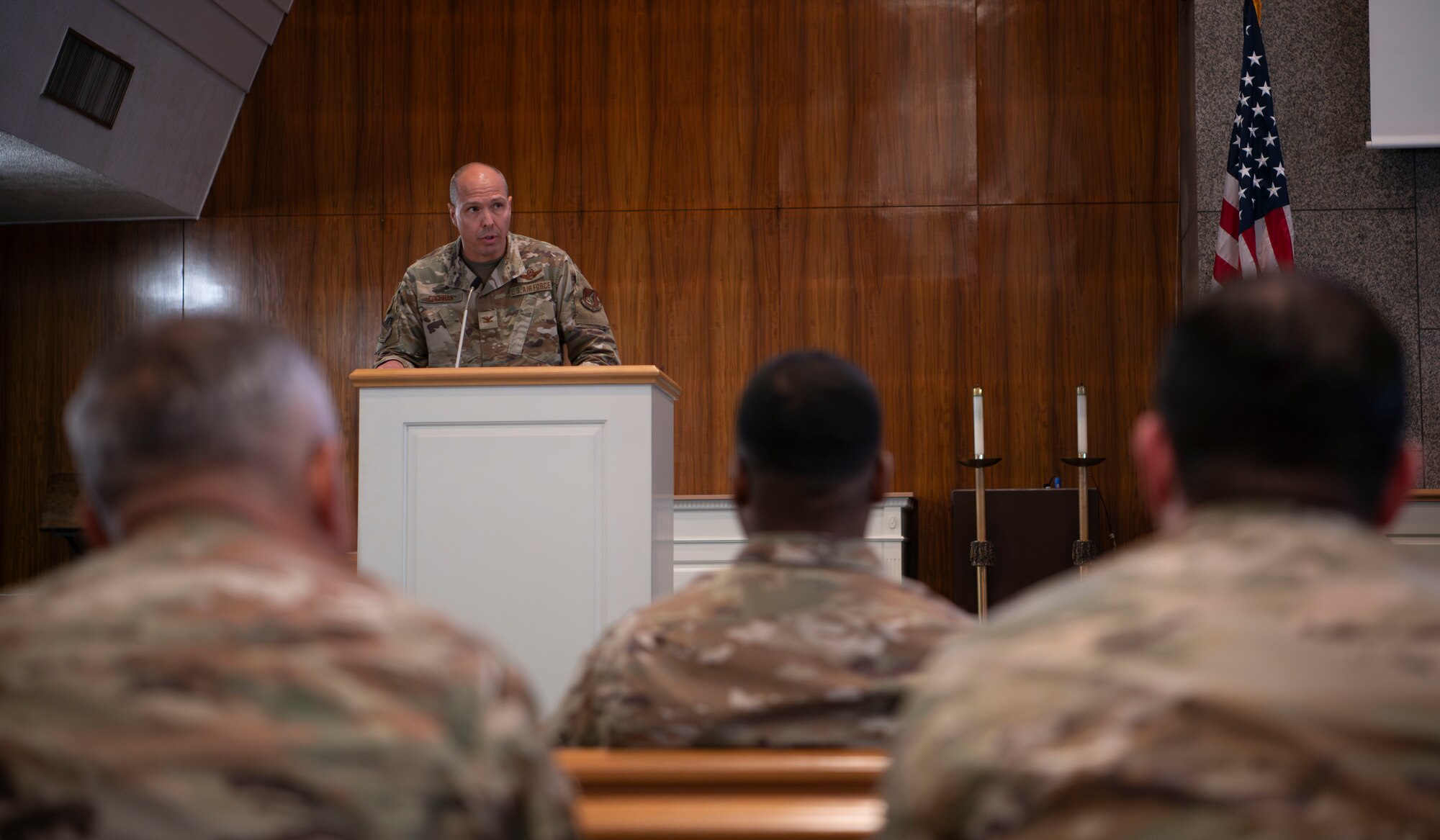 A military member speaks to a group of military members.