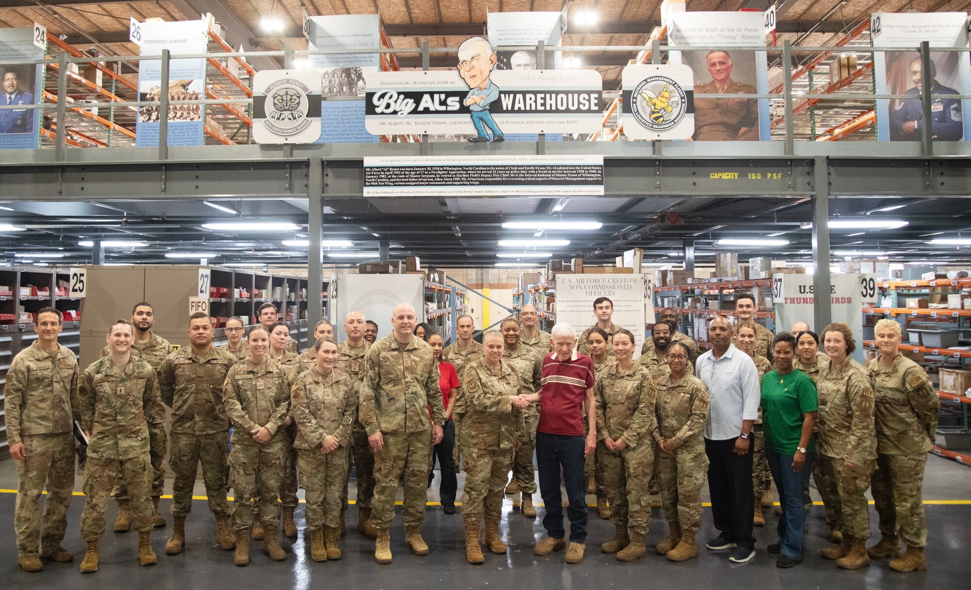 U.S. Air Force Lt. Gen. Linda S. Hurry, Deputy Commander, Air Force Materiel Command and members of the 96th Logistics Readiness Squadron materiel management flight, pose for a group photo below Big Al’s Warehouse sign inside the 96 LRS warehouse at Eglin Air Force Base, Fla.