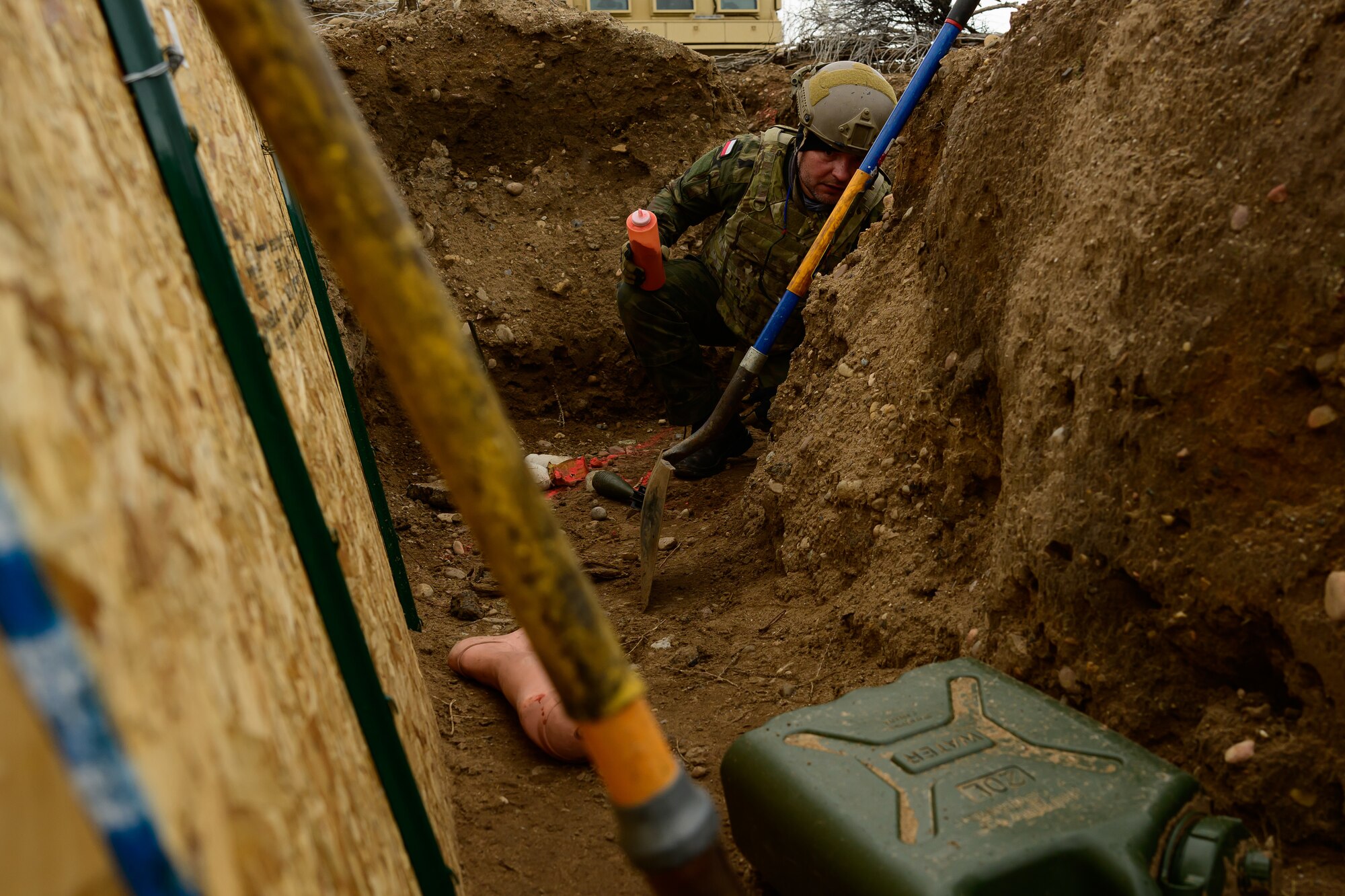 a military member works in a trench