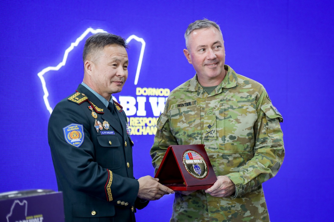 Brig. Gen. B. Uuganbayar, left, deputy director of the Mongolian National Emergency Management Agency, presents a commemorative anniversary plaque to Australian Maj. Gen. Scott Winter, deputy commanding general - strategy and plans for the U.S. Army Pacific, during the Gobi Wolf 2024 opening ceremony at the Governor’s Palace in Choibalsan, Mongolia, May 7, 2024.