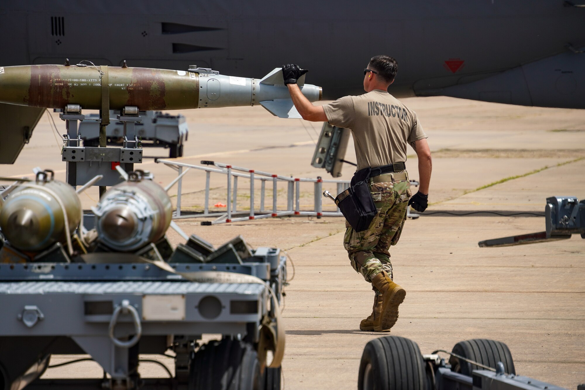 An Airman walks past a bomb