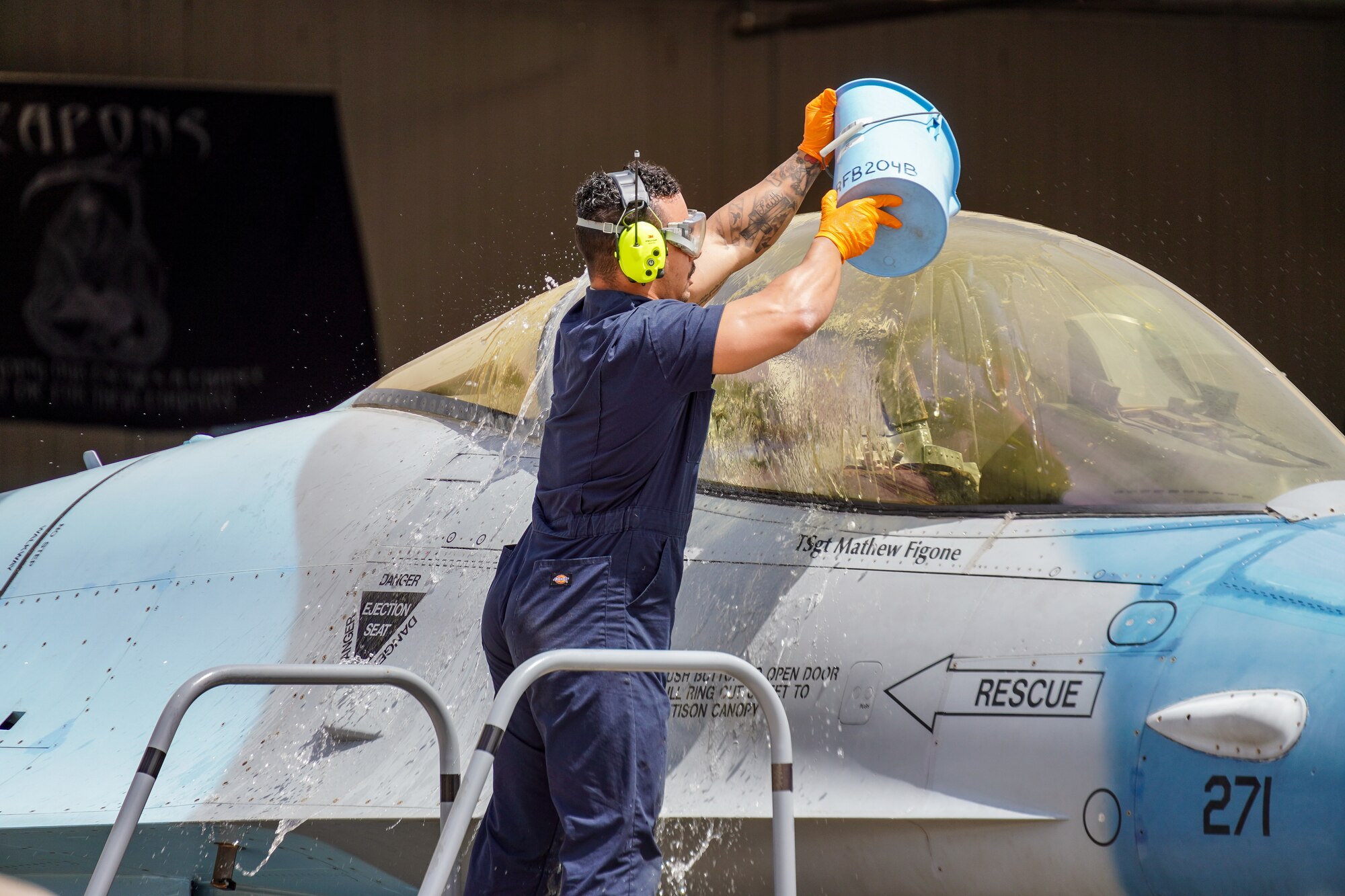An Airman washes a jet canopy