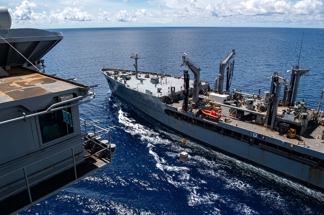 Two ships are connected by a cord in a body of water.