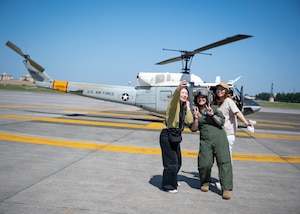 A flight engineer takes a selfie with two spouses.