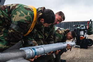 From left, Airman 1st Class Angel Lopez Moreno, Staff Sgt. Levi West and Senior Airman Nicholas Velasquez prepare to arm an F-16 Fighting Falcon.