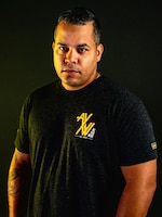 Man with a t-shirt standing in front of a black background.