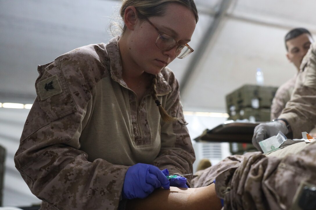 A U.S. Navy Hospital Corpsman with 2nd Distribution Support Battalion, Combat Logistics Regiment 2, 2nd Marine Logistics Group, prepares to put an intravenous liter of saline in a simulated heat casualty in preparation for exercise Native Fury 24 at a Logistics Support Area established in the Kingdom of Saudi Arabia, April 29, 2024. Exercise Native Fury 24 is a key multi-lateral exercise sponsored by U.S. Central Command and executed by U.S. Marine Corps Forces Central Command in collaboration with the Kingdom of Saudi Arabia and the United Arab Emirates. This iteration emphasizes the strategic use of logistics and leverage the extensive network of roads and infrastructure across the Arabian Peninsula. (U.S. Marine Corps photo by 2nd Marine Logistics Group)