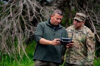 Command Sgt. Maj. John Hernandez, right, command sergeant major for Oklahoma, watches as an uncrewed aircraft systems operator pilots a UAS over the 2024 Oklahoma National Guard Best Warrior Competition at Camp Gruber Training Center April 26. This was the first time the OKARNG counter-UAS school integrated into the competition.