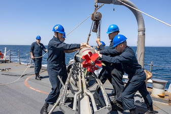 Sailors aboard USS Higgins (DDG 76) complete maintenance on a torpedo in the Philippine Sea.